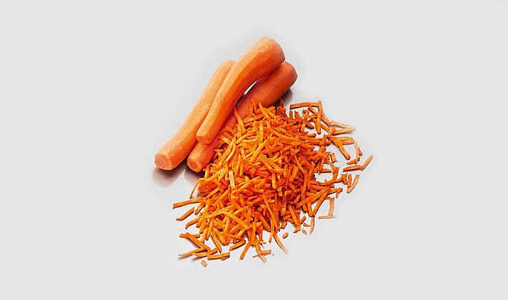 La cortadora con banda transportadora GS 20 de KRONEN corta hortalizas como, por ejemplo, zanahorias, para la aplicación industrial.