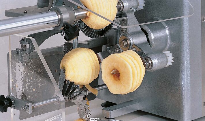 In addition to peeling, coring and segmenting the apples, the apple peeling and cutting machine AS 4 from KRONEN can also cut them into slices