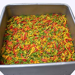 Thawed vegetables such as e.g. strips of bell pepper are dewatered quickly.