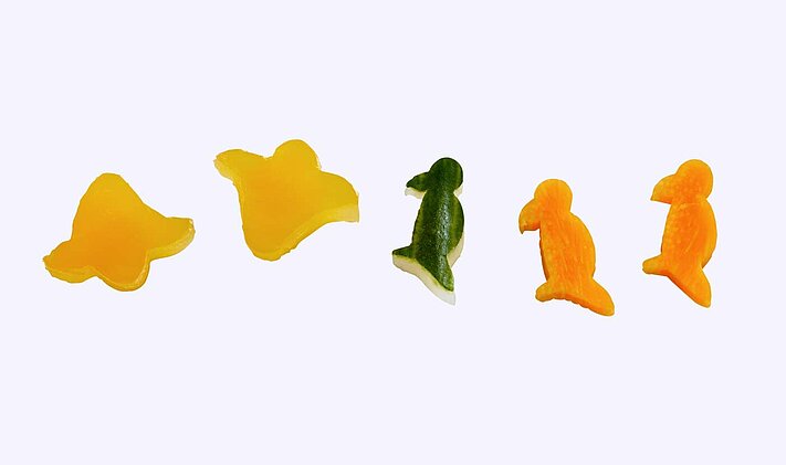 Des légumes de différentes formes coupés avec des accessoires pour figurines.