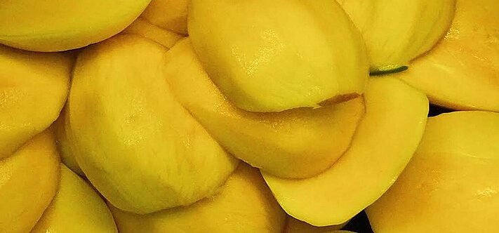 Mango halves that have been peeled and pitted with the mango peeler 20.